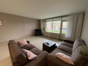 a living room with two couches and a large window at Rotterdam City Center in Rotterdam