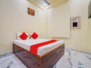 a bedroom with a bed with red pillows on it at OYO Flagship Hotel Moonlight in Rāipur