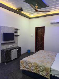 a bedroom with a bed and a flat screen tv at STAR HOTEL in Bahādurgarh