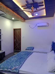 a bedroom with a bed and a ceiling fan at STAR HOTEL in Bahādurgarh