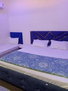 a large bed with a blue headboard in a room at STAR HOTEL in Bahādurgarh
