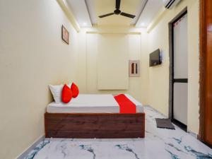 a bedroom with a bed with red pillows at OYO Flagship Hotel Moonlight in Rāipur