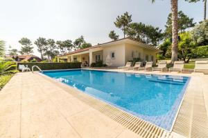 uma piscina em frente a uma villa em Villa Alecrim em Aroeira