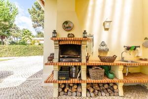 a kitchen with a fireplace in a house at Villa Alecrim in Aroeira