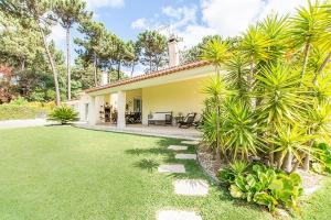 une maison avec une cour dotée d'une pelouse sidx sidx sidx dans l'établissement Villa Alecrim, à Aroeira