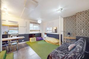 een slaapkamer met een bed en een keuken met een bureau bij Cosy 3BD maisonette in Ladbroke GroveNotting Hill in Londen