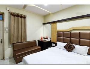 una camera d'albergo con letto e sedia di Hotel Swayam, Jabalpur a Jabalpur