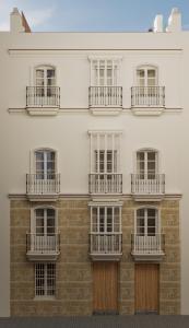 a large white building with windows and balconies at BYPILLOW Casa Gades in Cádiz
