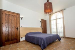 a bedroom with a bed and a chandelier at Résidence Prestige Odalys Les Villas Milady in Biarritz