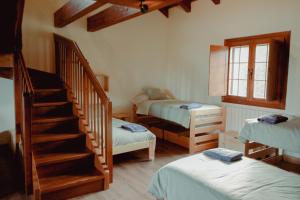 una habitación con 2 camas y una escalera en una casa en Casa Rural Ger 