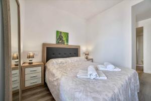a bedroom with a bed with towels on it at Apartamento Mirador - PlusHolidays in Calpe