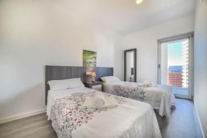 a hotel room with two beds and a window at Apartamento Mirador - PlusHolidays in Calpe