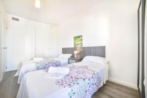 two beds in a room with white walls at Apartamento Mirador - PlusHolidays in Calpe