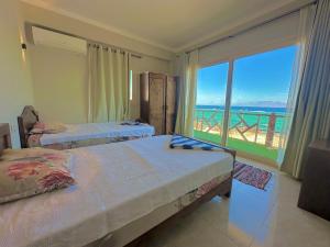 a bedroom with two beds and a view of the ocean at Moon house n.30 in Dahab