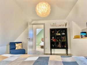 1 dormitorio con silla azul y lámpara de araña en Komfortable Designerwohnung - 3 Schlafzimmer, en Landshut