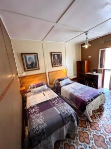 Zimmer mit 2 Betten und einem Schreibtisch. in der Unterkunft Les IRIS in Al Hoceïma