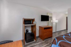 a hotel room with a bed and a television at Super 8 by Wyndham Clayton in Clayton