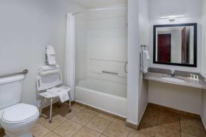 a bathroom with a toilet and a tub and a sink at Super 8 by Wyndham Clayton in Clayton +8 photos