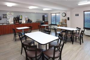 ein Restaurant mit Tischen und Stühlen und einer Theke in der Unterkunft Super 8 by Wyndham Wausau in Wausau