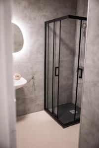 a shower with a glass door next to a sink at Le Grand Som - Chambres au coeur de la Chartreuse in Saint-Pierre-dʼEntremont