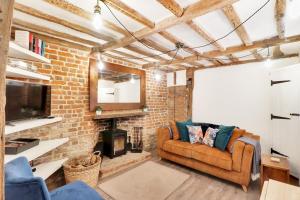 sala de estar con sofá y chimenea en Perfectly Presented Cottage Pass the Keys en Robertsbridge