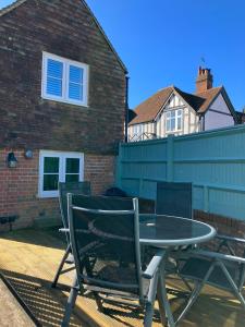 a table and chairs sitting on a patio at Perfectly Presented Cottage Pass the Keys in Robertsbridge