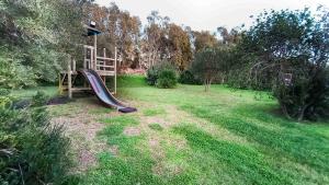 a playground in a yard with a slide at Alghero - Grotte di Nettuno cortes in Santa Maria la Palma