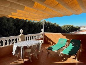 patio con mesa y sillas en el balcón en Apartamentos Maria, en Málaga