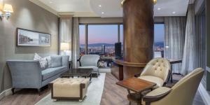 a living room with a couch and chairs and a television at Hilton Bursa Convention Center & Spa in Bursa