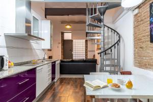 a kitchen and living room with a spiral staircase at AB Modern Gracia Apartment in Barcelona