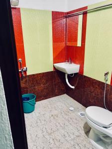 a bathroom with a toilet and a sink at Puthookkadans Mareena Lodge in Kottayam