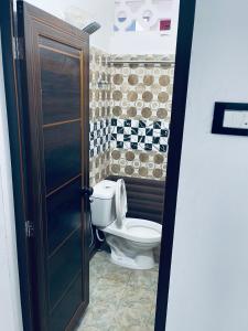 a bathroom with a toilet in a room at Puthookkadans Mareena Lodge in Kottayam