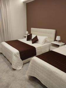 a bedroom with two beds and two tables with lamps at monolocale speedy in Fiumicino