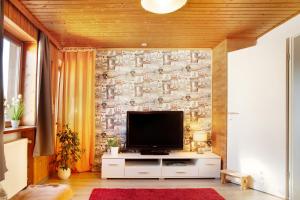 a living room with a tv on a stone wall at Horst in Perach
