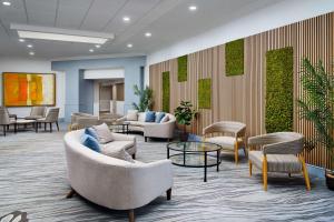 a waiting room with couches and chairs and tables at DoubleTree by Hilton Rocky Mount in Rocky Mount