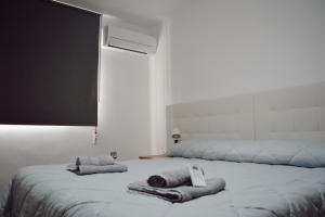 a bedroom with two beds with towels on it at Apartamentos Maria in Málaga