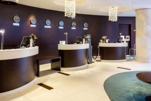 a lobby with two counters with clocks on the wall at Radisson Blu Hotel Kaliningrad in Kaliningrad