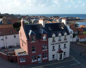 a red and white building with the dolphin inn on it at The Dolphin Inn Hostel in Dunbar