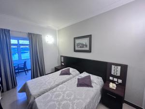 a hotel room with a bed and a window at Grand Harbour Hotel in Valletta