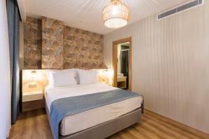 a bedroom with a bed and a chandelier at Güllük Uno Elegance Otel in Gulluk +40 photos