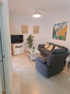 ein Wohnzimmer mit Sofa und Fernseher in der Unterkunft Costa Ballena - El Paraíso in Rota