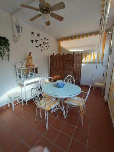 ein Esszimmer mit Tisch und Stühlen und einem Deckenventilator in der Unterkunft Costa Ballena - El Paraíso in Rota