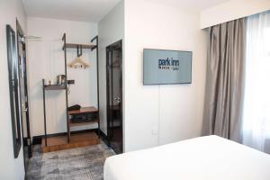 a bedroom with a bed and a television on a wall at Park Inn by Radisson Bournemouth in Bournemouth