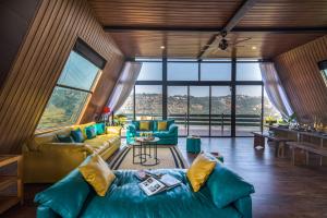 a living room with a couch and a table at SaffronStays A Vantage, Panchgani - A Pyramid Shaped Unique Luxury Villa With Infinity Valley Views in Panchgani