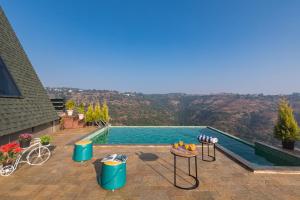 a swimming pool with a view of a mountain at SaffronStays A Vantage, Panchgani - A Pyramid Shaped Unique Luxury Villa With Infinity Valley Views in Panchgani