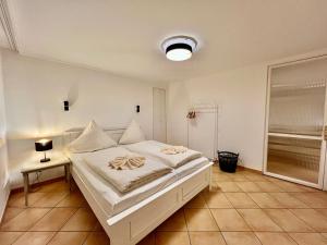 ein Schlafzimmer mit einem weißen Bett in einem Zimmer in der Unterkunft Penthouse-Berta in Westerland