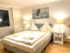 ein Schlafzimmer mit einem großen Bett mit weißen Laken und Kissen in der Unterkunft Penthouse-Berta in Westerland