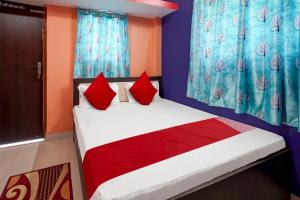 a bedroom with a bed with red pillows at OYO Flagship Hotel R.M in Patna