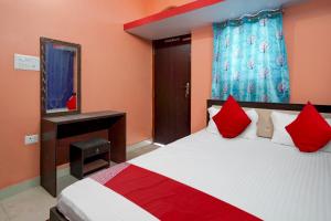 a bedroom with a bed with red pillows and a mirror at OYO Flagship Hotel R.M in Patna