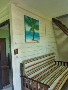 een bankje in een kamer met een foto van een palmboom bij Chalé Carvalho - Verde in Itapoa